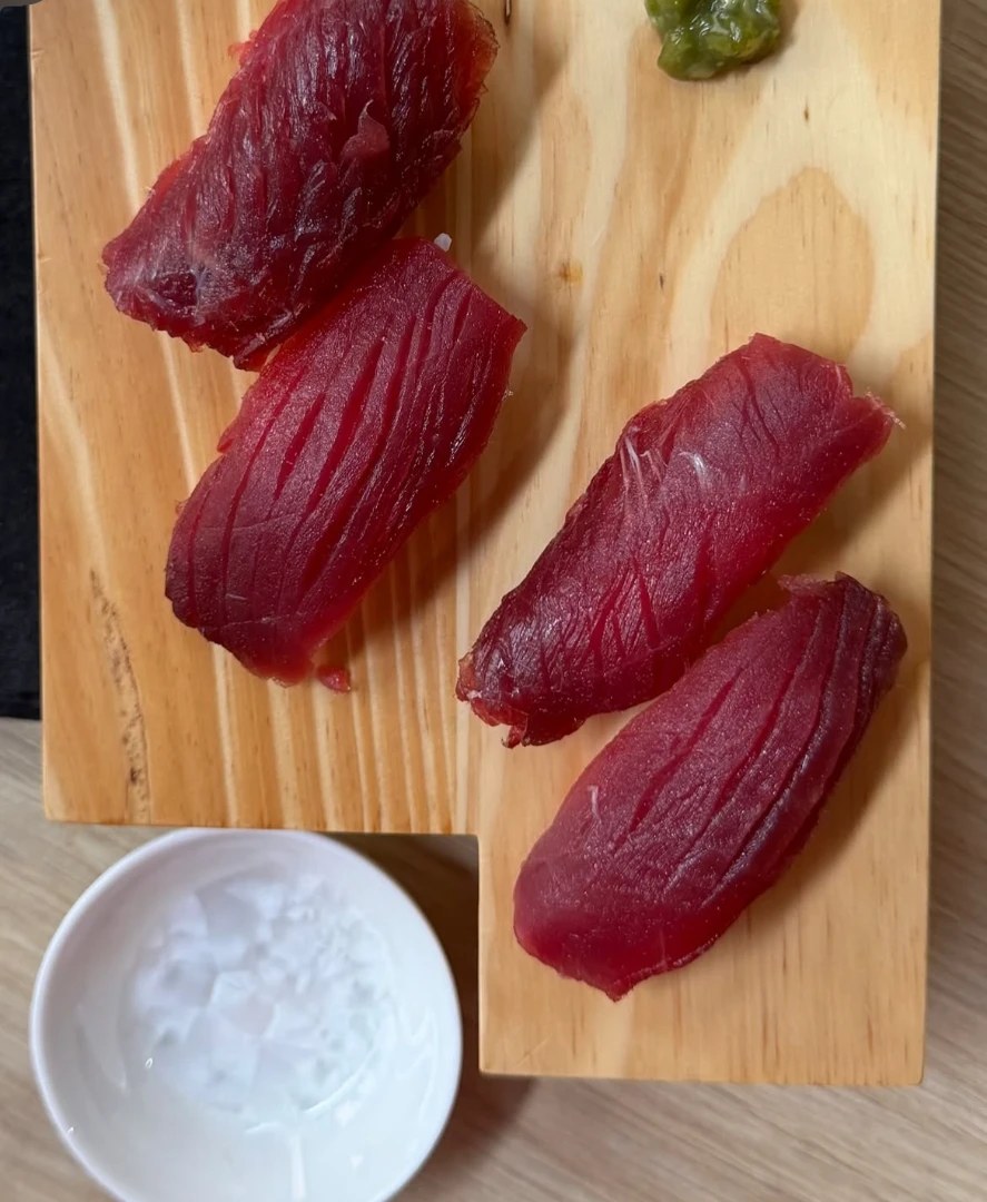 Quattro nigiri di tonno rosso su asse di legno